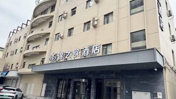 A hotel with a modern facade, multiple floors, and a prominent entrance.