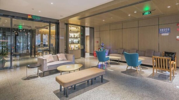 En moderne lobby med siddeområder, en receptionsdisk og en glasfacade.