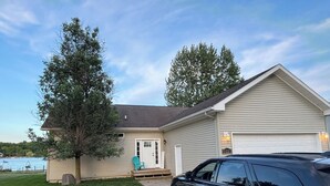 Ein zweistöckiges Haus mit Garage, Auffahrt und einem großen Baum im Vorgarten.