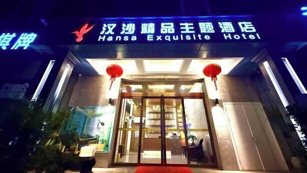 Das Hotel Hansa Exquisite mit markantem Eingangsbereich und beleuchteter Beschilderung.