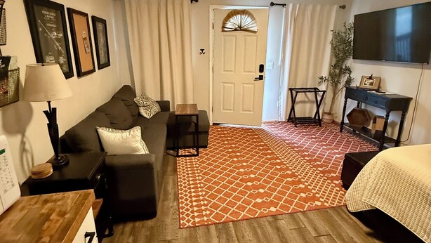 A compact living space with a sofa, a small table, a TV, and a patterned rug. - Pet friendly cabin in quiet Plainview with WiFi, AC (Plainview)