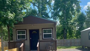 A small cabin with a front porch, a door, and two windows. - Pet friendly cabin in quiet Plainview with WiFi, AC (Plainview)
