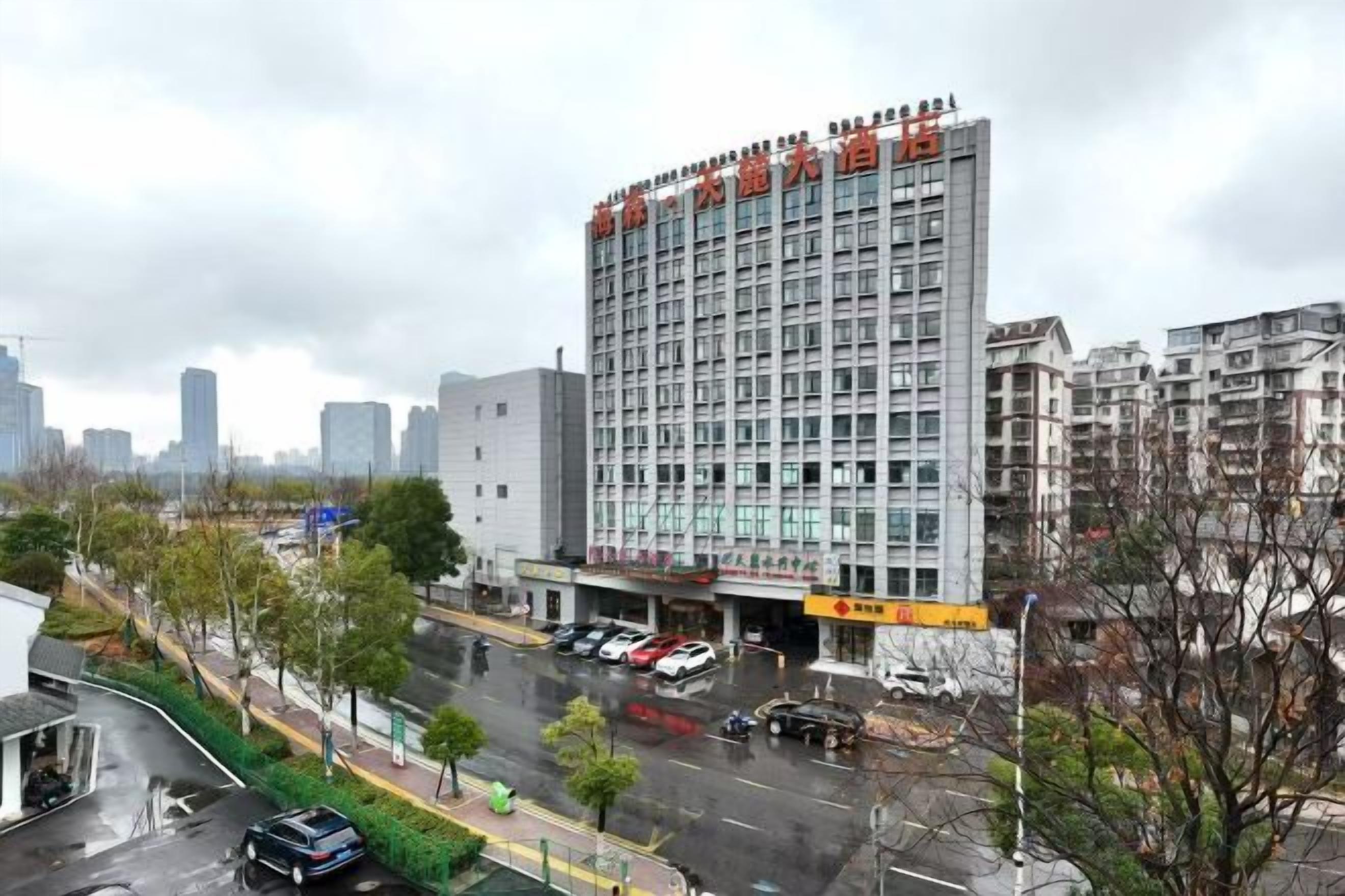 Ein mehrstöckiges Gebäude mit einer gewerblichen Erdgeschossnutzung, umgeben von einer Stadtlandschaft und einer nassen Straße.