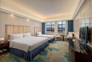 A hotel room with two beds, a desk, a chair, a TV, and a large window with a city view. - Handsome Tianlu Hotel (Changsha)