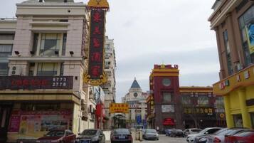 Una calle con edificios, automóviles y un letrero llamativo.
