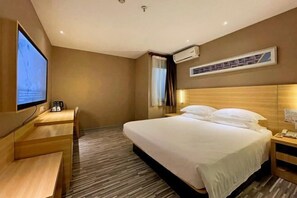 A hotel room with a bed, a desk, a television, and an air conditioning unit. - Tulou·He Hotel (Shanghai Songjiang New City Metro Station Branch) (Shanghai)