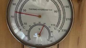 Un thermomètre-hygromètre fixé à un mur en bois.
