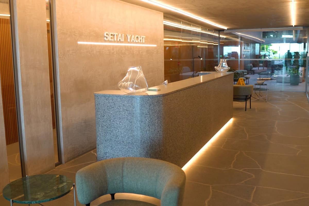 A reception area with a stone counter, a glass table, and a seating area with chairs and a sofa.