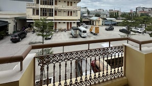 A multi-story building with a balcony in the foreground. - OYO 1246 Nha Khach Cuc Hau Can (Da Nang)