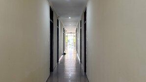 A long, narrow hallway with a tiled floor and white walls. - OYO 1246 Nha Khach Cuc Hau Can (Da Nang)