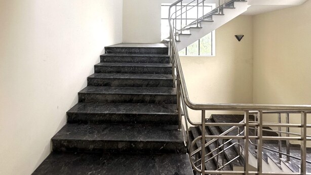 A staircase with a metal railing leading to an upper floor. - OYO 1246 Nha Khach Cuc Hau Can (Da Nang)