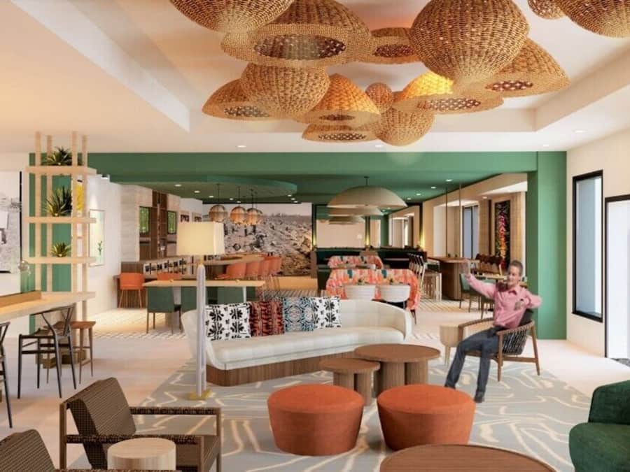A spacious lobby with a sofa, chairs, a bar area, and a fireplace.