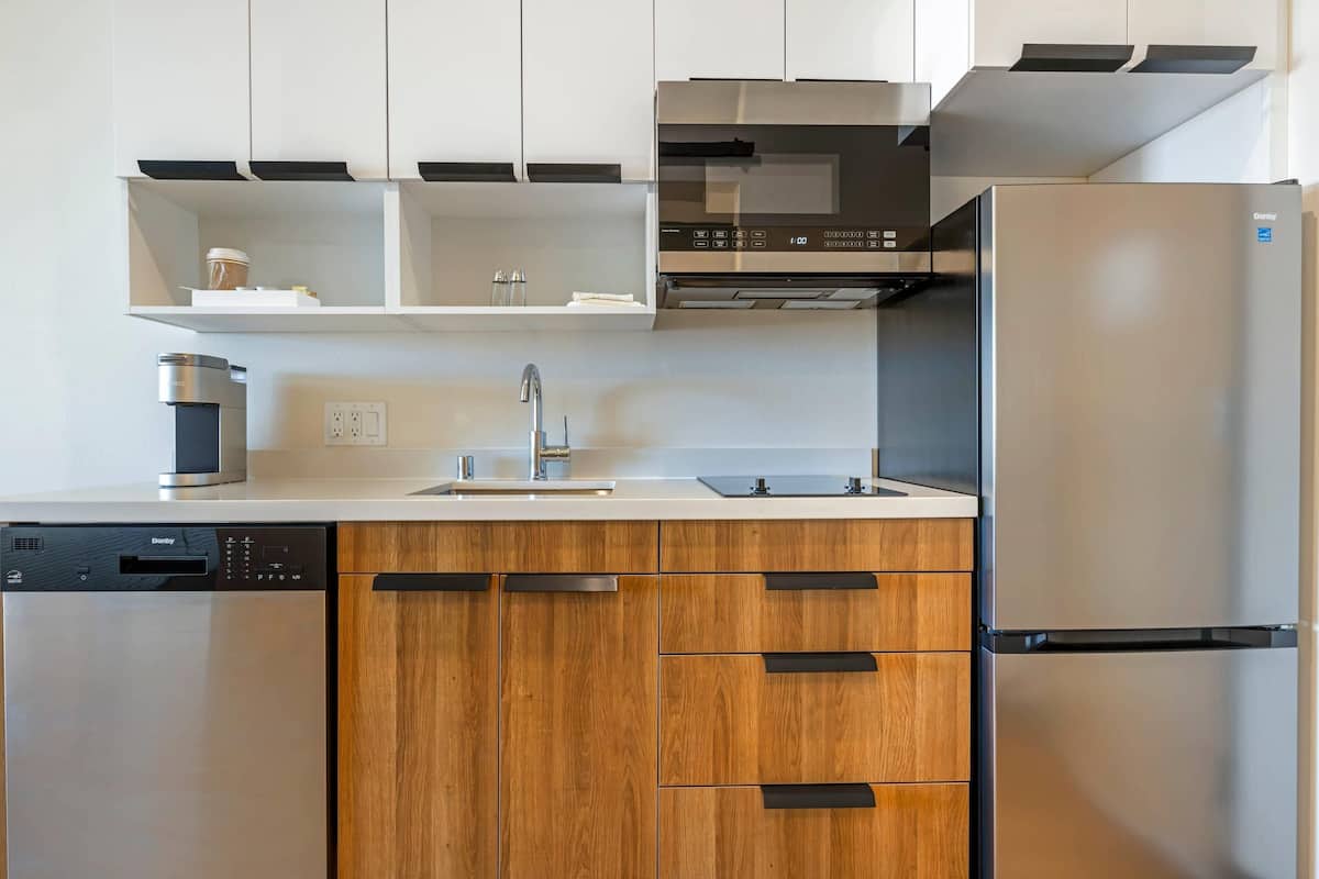 Una cocina moderna con lavavajillas, fregadero y electrodomésticos de acero inoxidable.