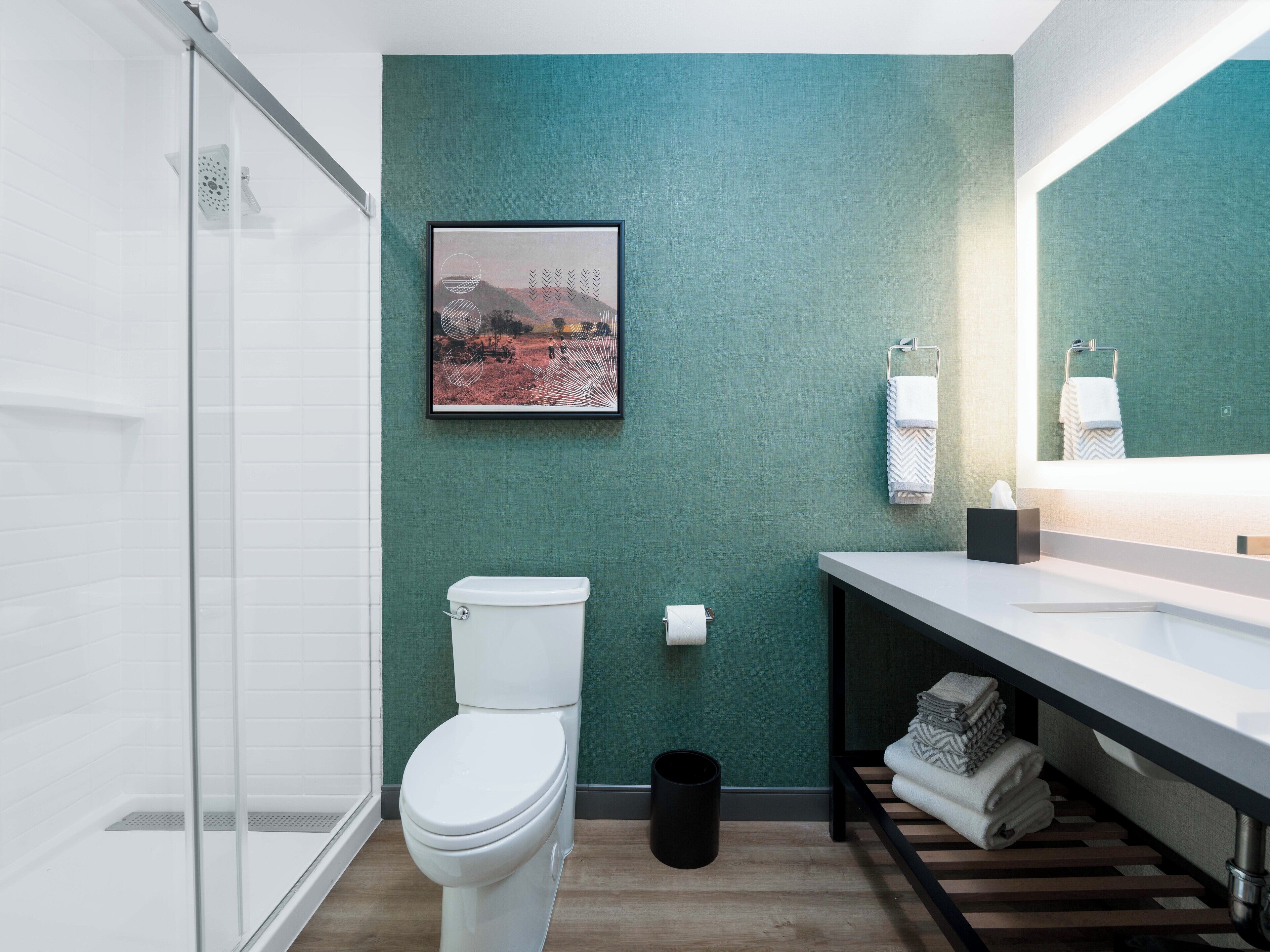 A modern bathroom with a toilet, sink, and shower.