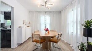 A modern dining area with a round table, four chairs, and a chandelier. - Modern Cottage in Columbus (Columbus)