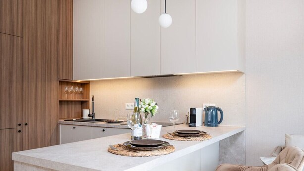 A modern kitchen with a central island, wooden cabinets, and pendant lighting. - Łódź Wólczańska - Workspace & Balcony - by Rentujemy (Łódź)