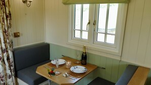 Een eethoek met een tafel voor twee, een fles champagne en een raam met uitzicht.