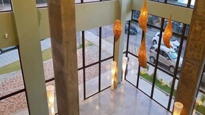 A modern interior with large windows, hanging pendant lights, and a clean, tiled floor. - ILUSION VISTA PANORÂMICA (Natal)