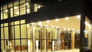 A modern building with large glass windows and a well-lit entrance. - ILUSION VISTA PANORÂMICA (Natal)