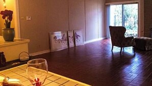 A spacious living room with a large window, a fireplace, and a dining area with a table set for two. - 2-bedroom apartment in enchanting Fort Worth with AC (Fort Worth)