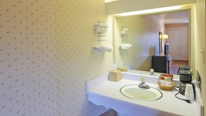 A bathroom with a sink, mirror, towel rack, and toiletries. - Hotel O Relax Inn Lewisburg near I-64 (Lewisburg)