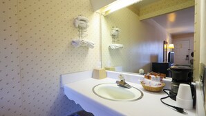 A hotel bathroom with a sink, mirror, towel rack, and a coffee maker. - Hotel O Relax Inn Lewisburg near I-64 (Lewisburg)