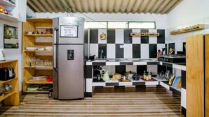 A compact kitchen with a refrigerator, checkered backsplash, and wooden shelves. - Finca Umnisa  Choachi (Choachí)