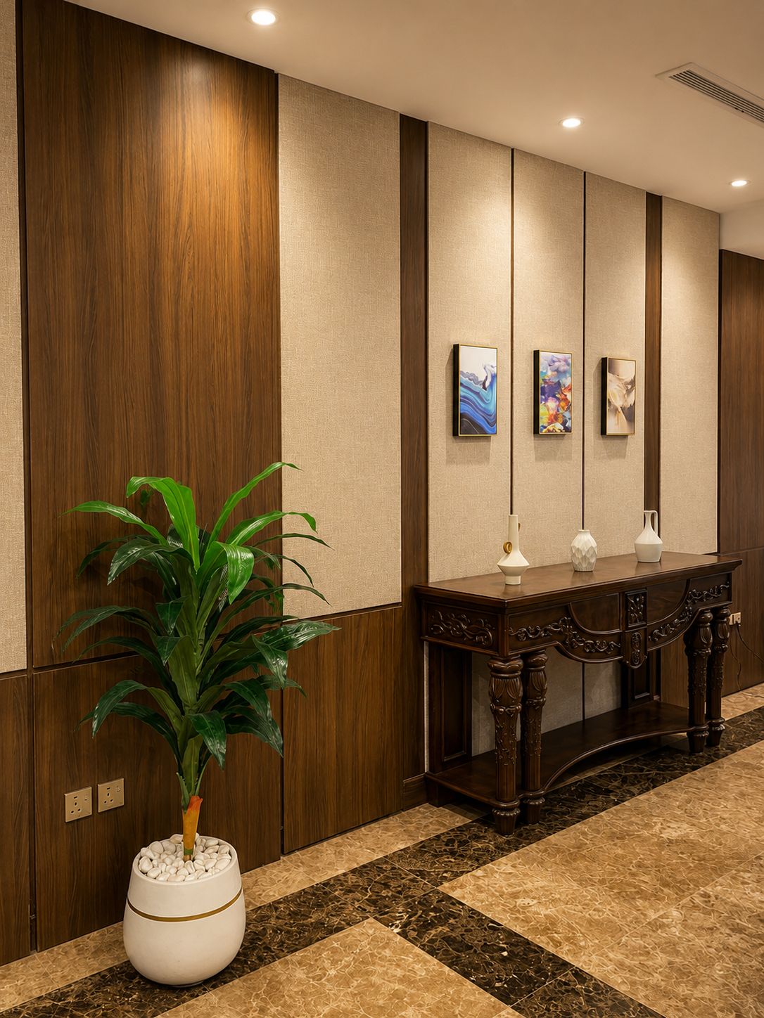 Un hall d’hôtel avec un mur lambrissé en bois, une plante en pot, une console ornée de vases et des œuvres d’art accrochées au mur.