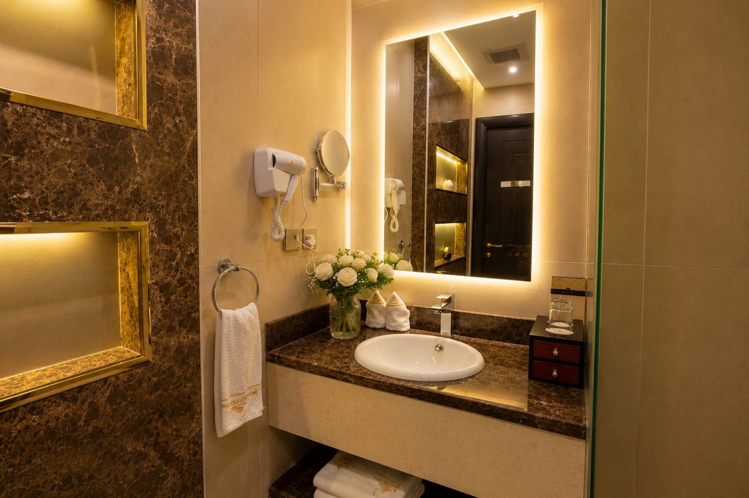 A bathroom with a marble countertop, a sink, a mirror, a hairdryer, and a towel rack.