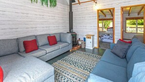 A living room with a grey sofa, a blue sofa, a patterned rug, and a fireplace.