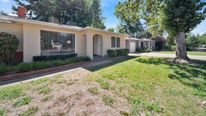 A row of single-story houses with a uniform architectural style, featuring a central entrance and a covered front porch. - Comfortable home near river access trail (Redding)