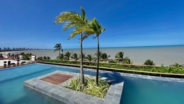 Una piscina con vista a la playa y al océano.