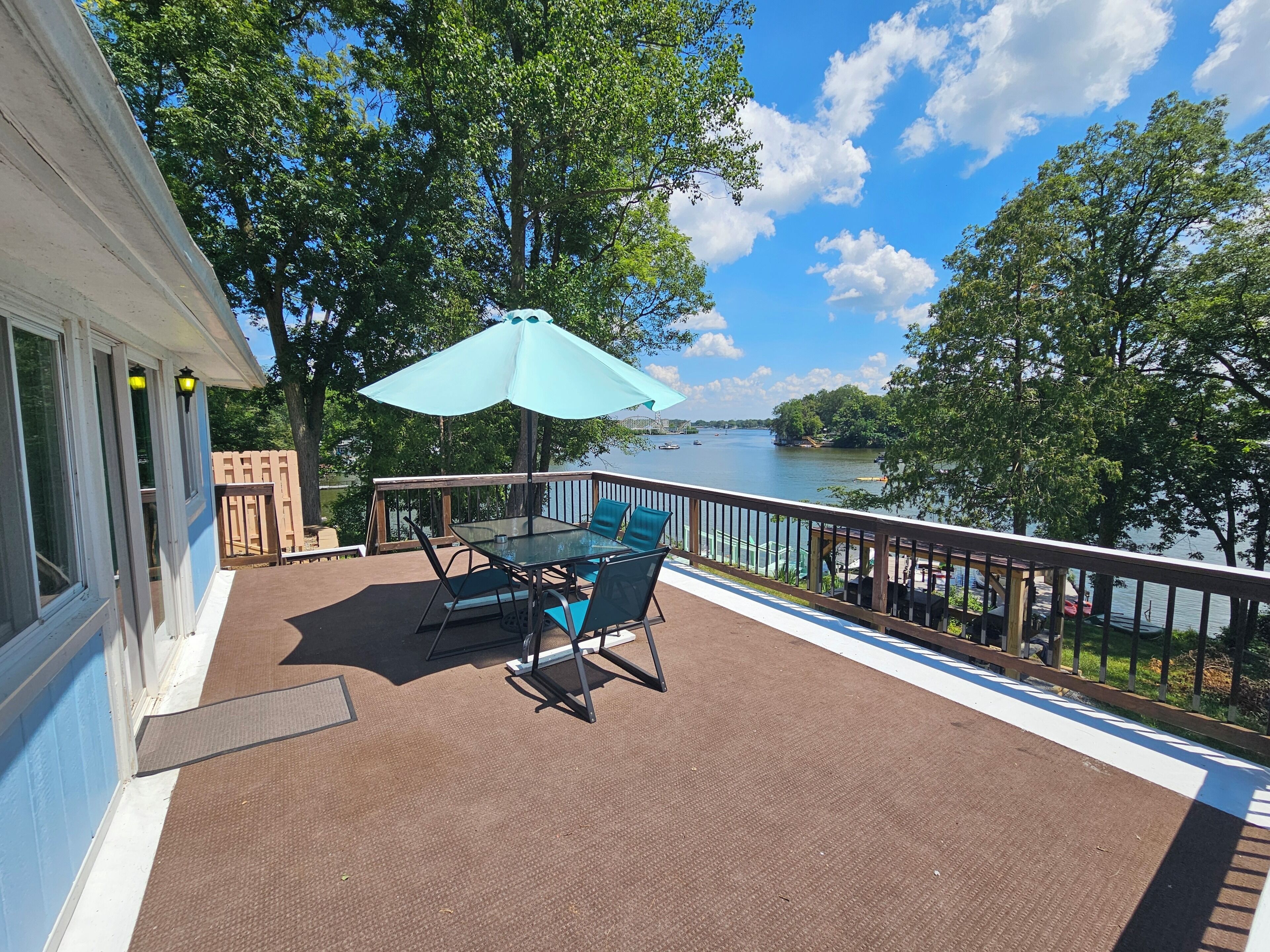 Une terrasse avec une table et des chaises, donnant sur un lac.