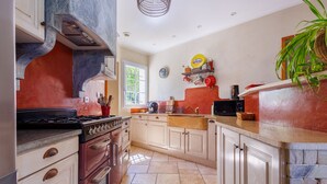 A kitchen with a stove, oven, and cabinets. - La Maison de Mathis - Maison avec piscine privée (Valréas)