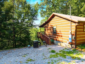 A wooden cabin with a porch, surrounded by trees. - Point of View Cabin · Private Hot Tub, Fire Pit & Mountain Views · Dog-Friendly (Sevierville)