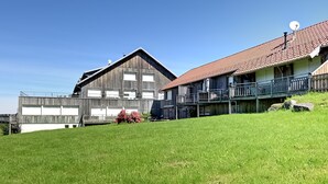 A two-story building with a sloped roof and a balcony on the second floor. - Le Nid des Vosges - Appt vue montagne (Gérardmer)