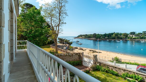 A balcony with a view of a beach and boats.