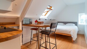 A compact, modern room with a kitchenette, a dining area, and a bed. - La Timonerie - Studio climatisé à Bénodet (Benodet)