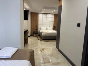 Habitació triple Deluxe, vistes a la ciutat | Caixa forta a l'habitació, decoració individual i mobiliari individual