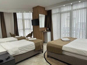 Deluxe Quadruple Room, City View | Peti besi dalam bilik, dihias secara berasingan 