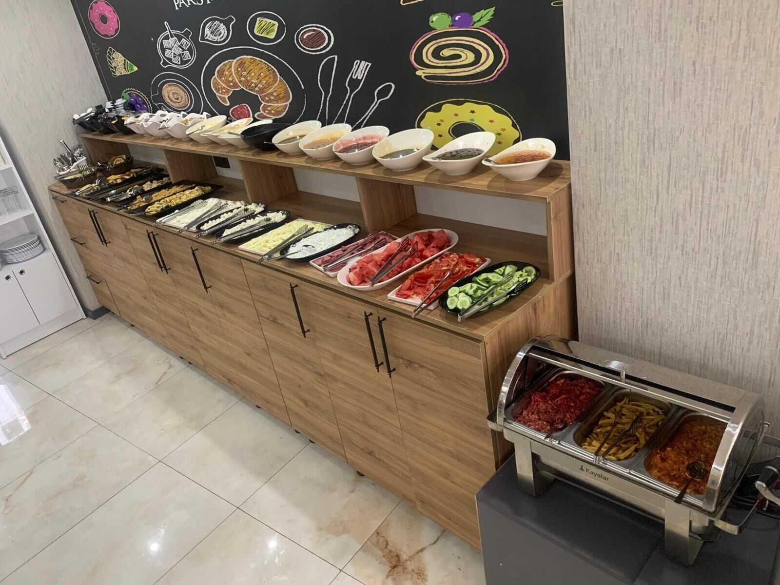 A buffet setup with various food items and utensils.