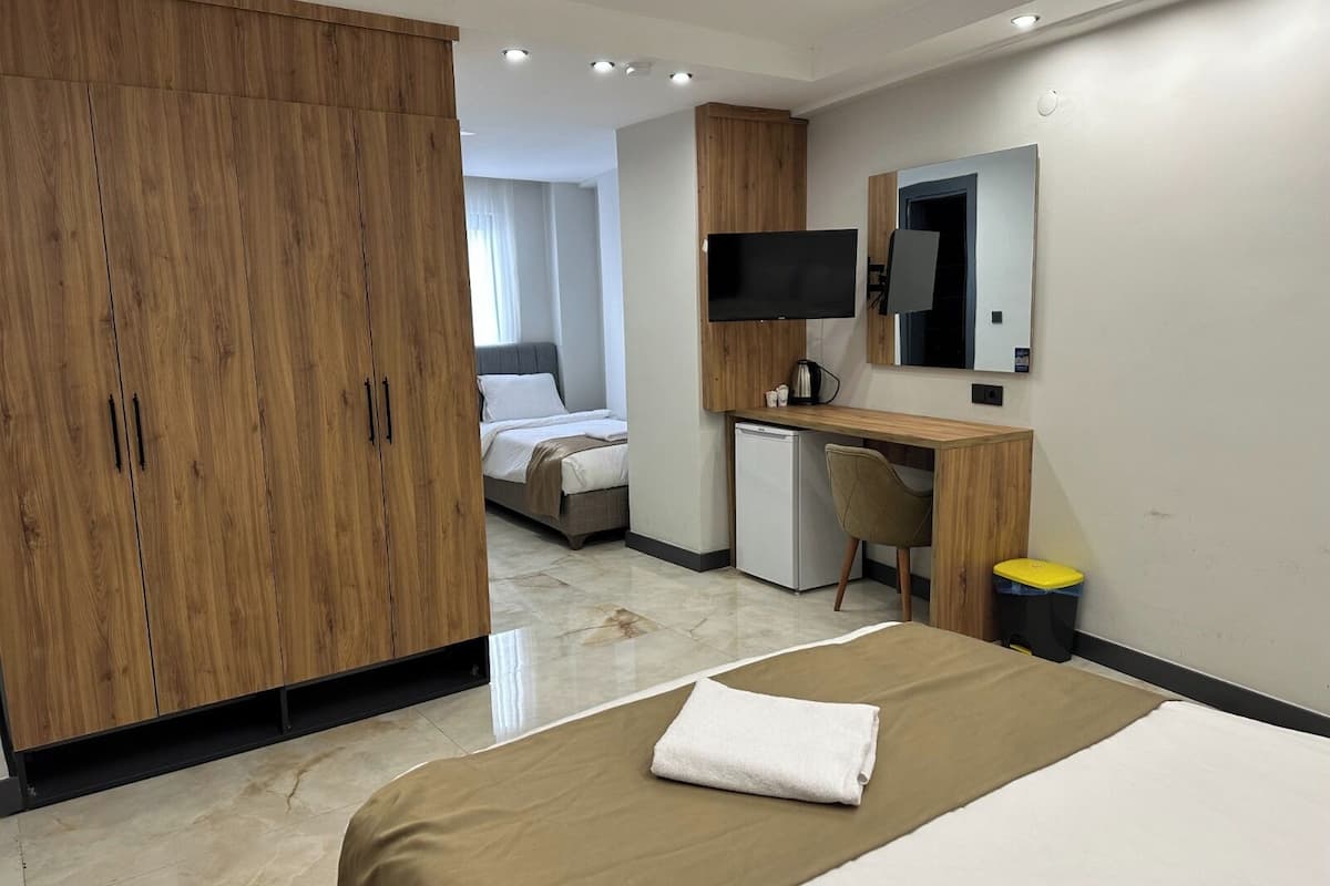 Une chambre d’hôtel équipée d’un lit, d’un bureau, d’une télévision et d’une armoire.