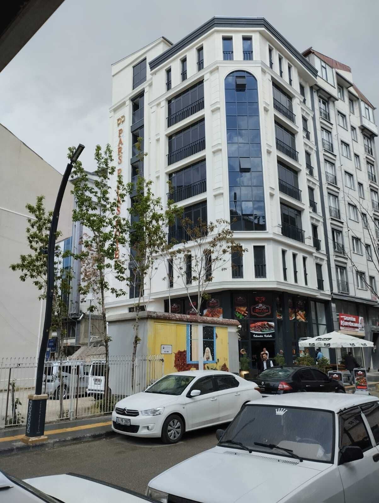 A multi-story building with a white facade and large windows.