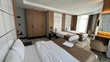 Deluxe Quadruple Room, City View | In-room safe, desk, laptop workspace, blackout drapes