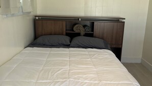 A bed with a white duvet, two pillows, and a wooden headboard. - LUX 5 - Cozy 1-bed 1bath w/ WiFi, AC in a beautiful neighborhood in Nassau city (Nassau)