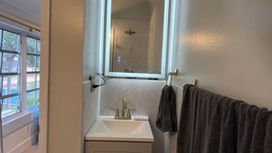 A bathroom with a white sink, a mirror, and a towel rack. - LUX 5 - Cozy 1-bed 1bath w/ WiFi, AC in a beautiful neighborhood in Nassau city (Nassau)
