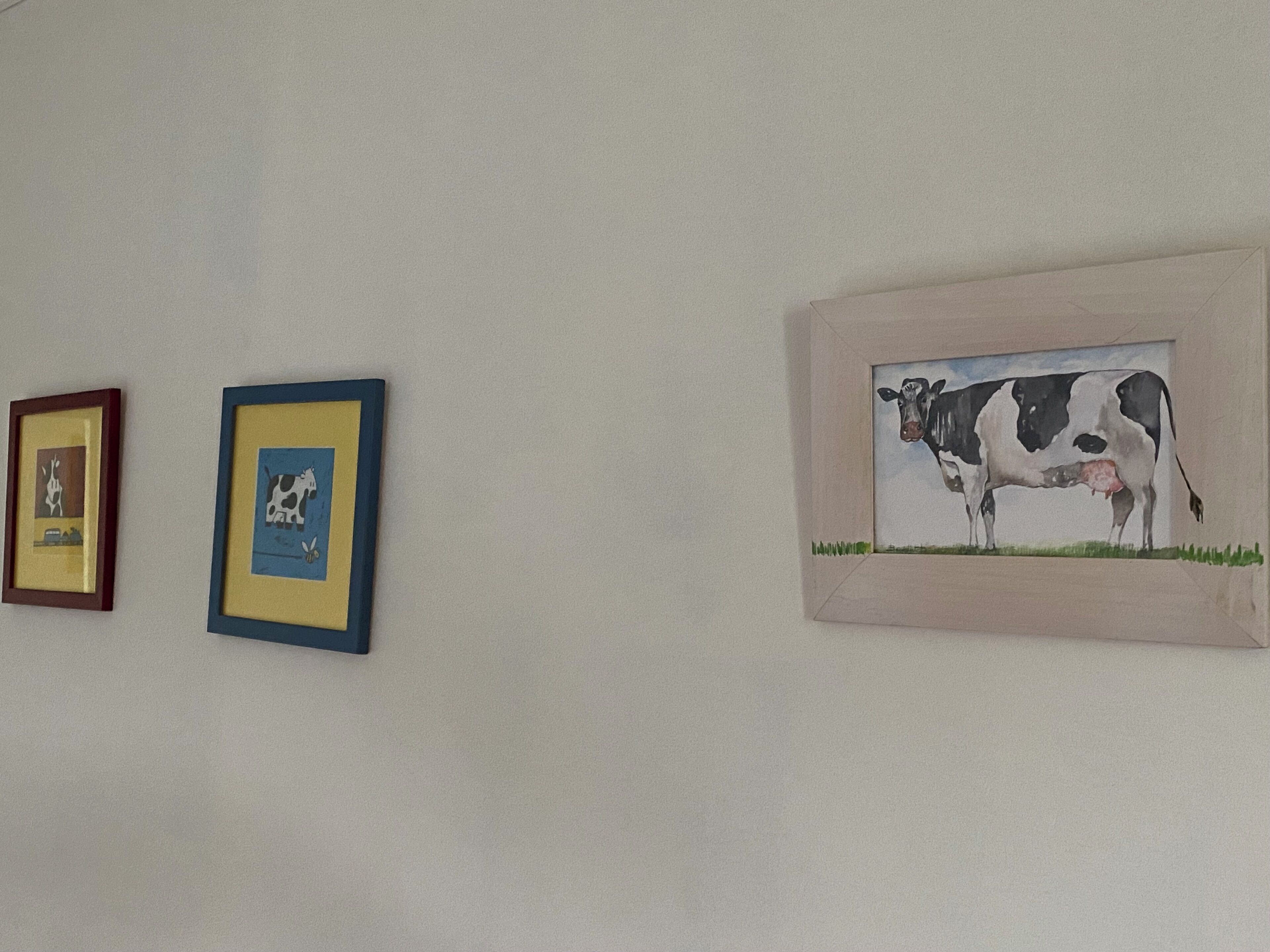 Three framed artworks on a wall.