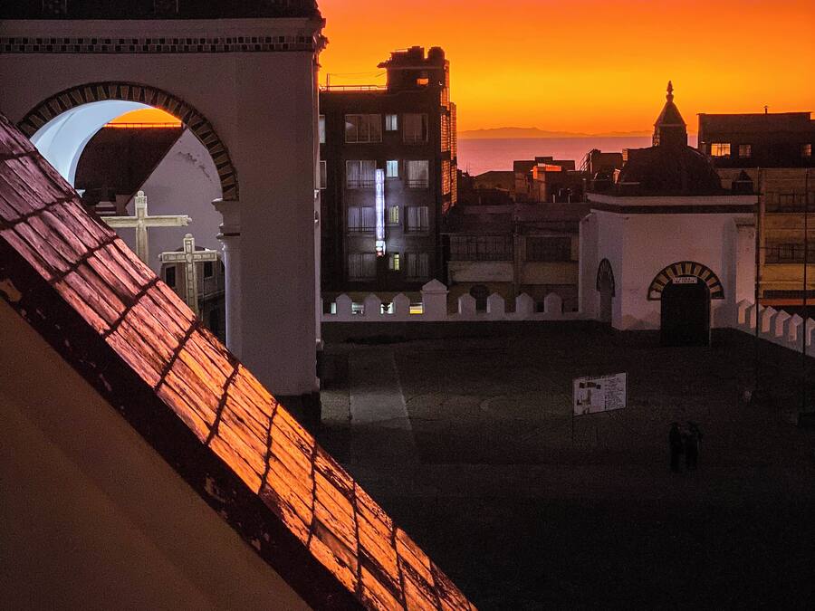 A historic building with a prominent archway and a dome, set against a sunset sky.