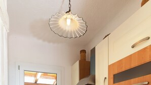 Cocina con estufa a gas, horno, pileta y alacenas de madera.