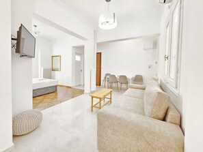 Ein modernes Wohnzimmer mit einer Couch, einem Couchtisch und einem an der Wand befestigten Fernseher.
